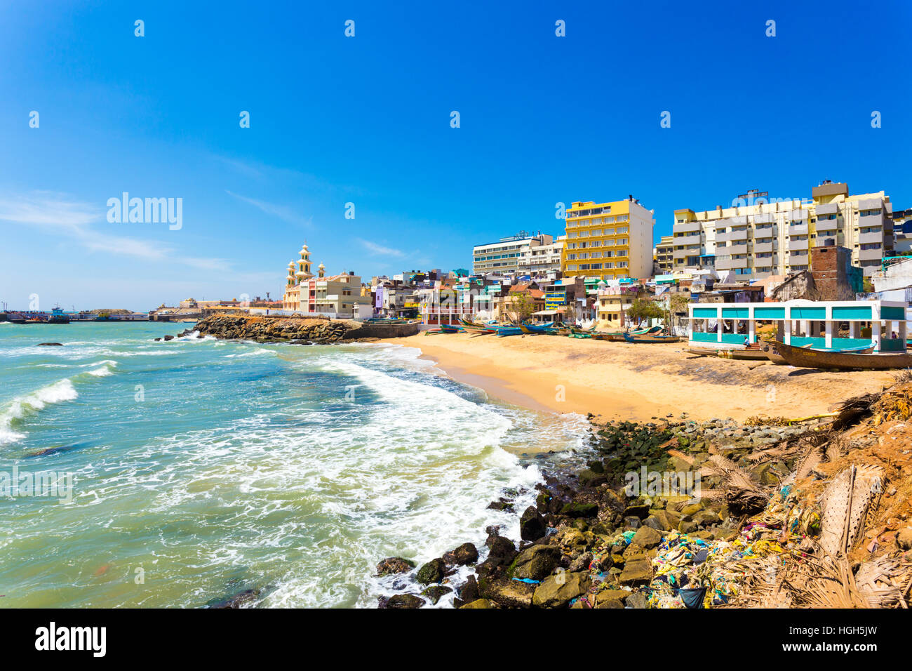 Colorful houses and large concrete hotels line a small beach near St Arokiyanathar Alayam Church at the southernmost tip India Stock Photo