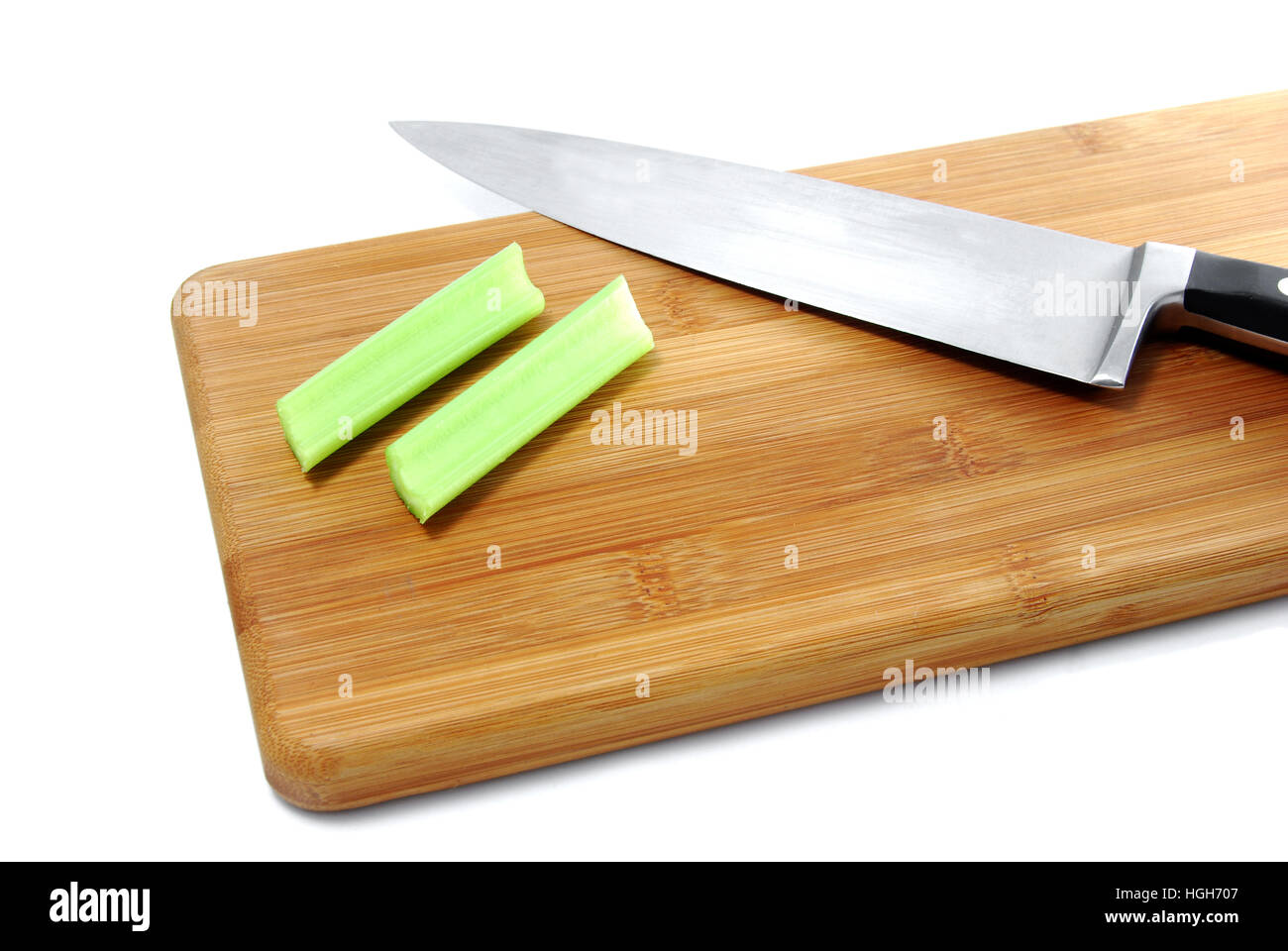 Cutting and preparing celery on cutting board with knife for healthy snack food that is kid friendly. Stock Photo