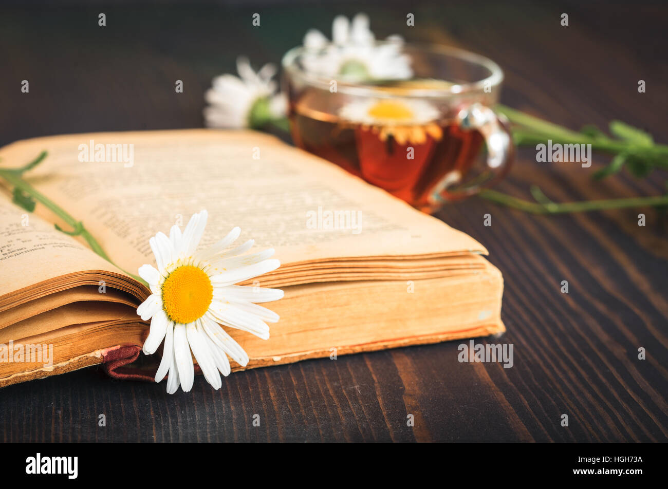 Cup of tea, chamomile and a book on the wooden table Stock Photo - Alamy