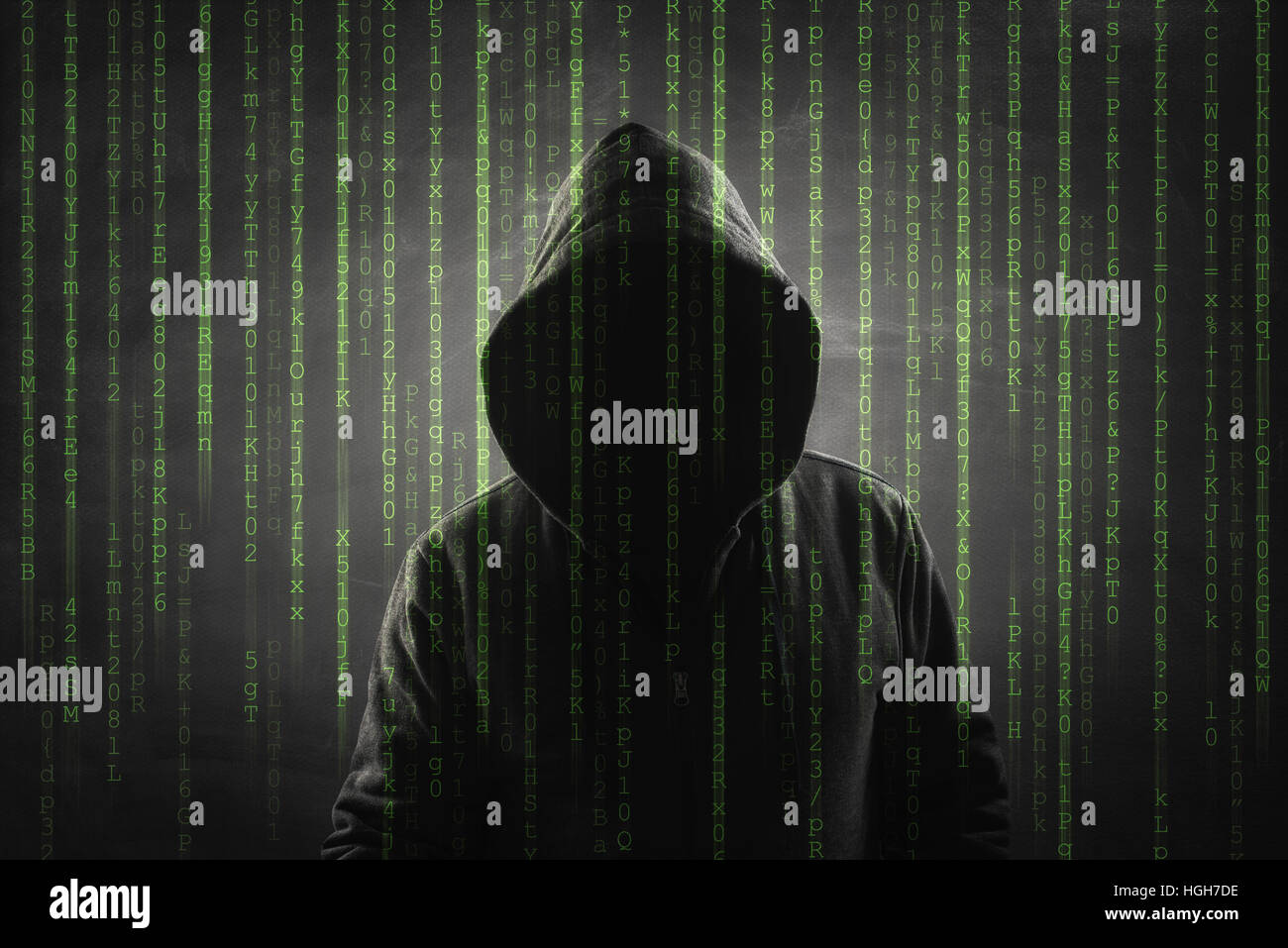 hacker over a screen with binary code Stock Photo