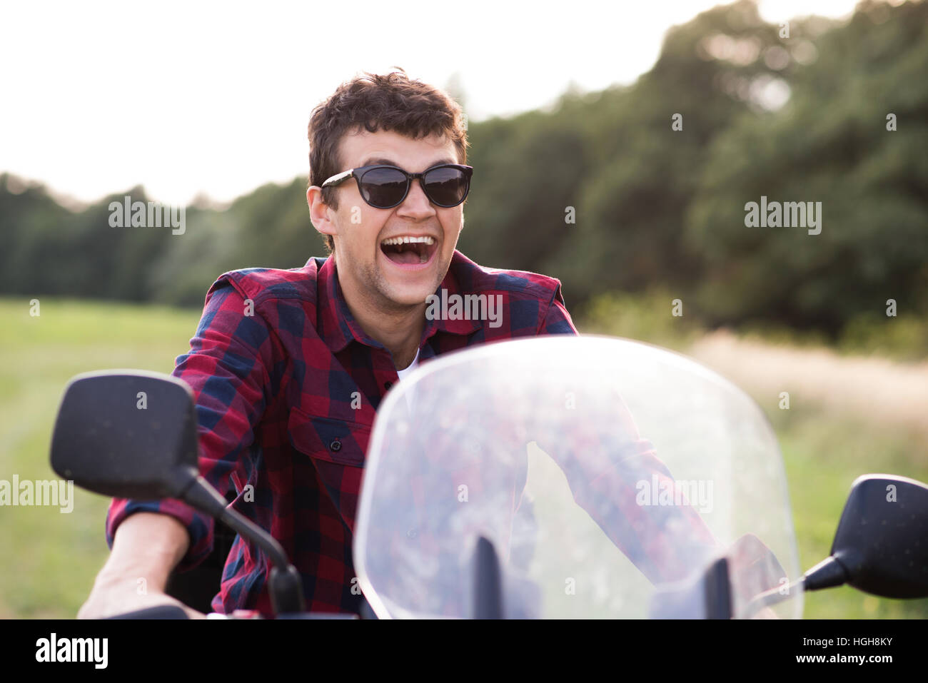 Young man enjoying a motorbike ride in countryside. Stock Photo