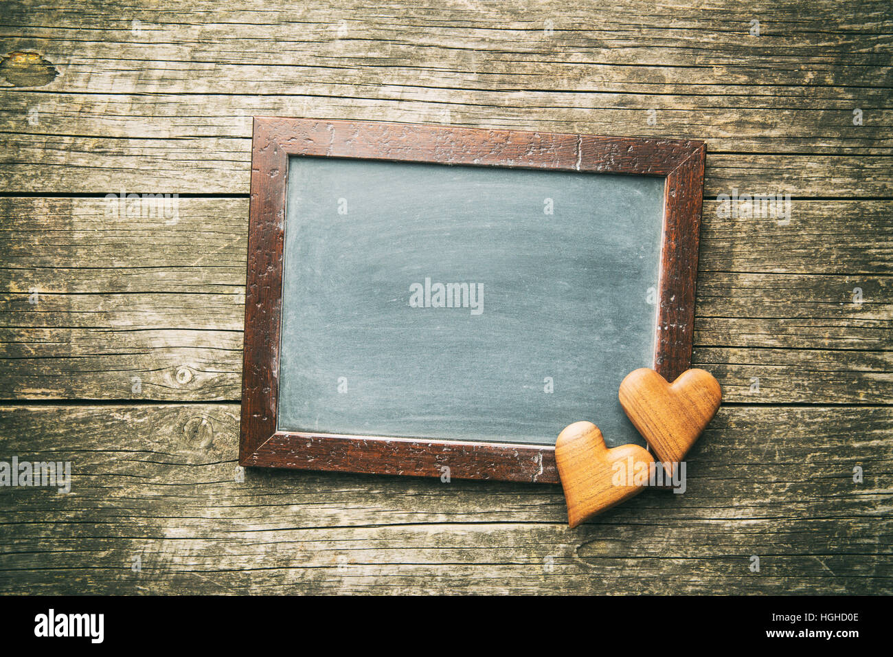 Black chalkboard and wooden hearts. Stock Photo
