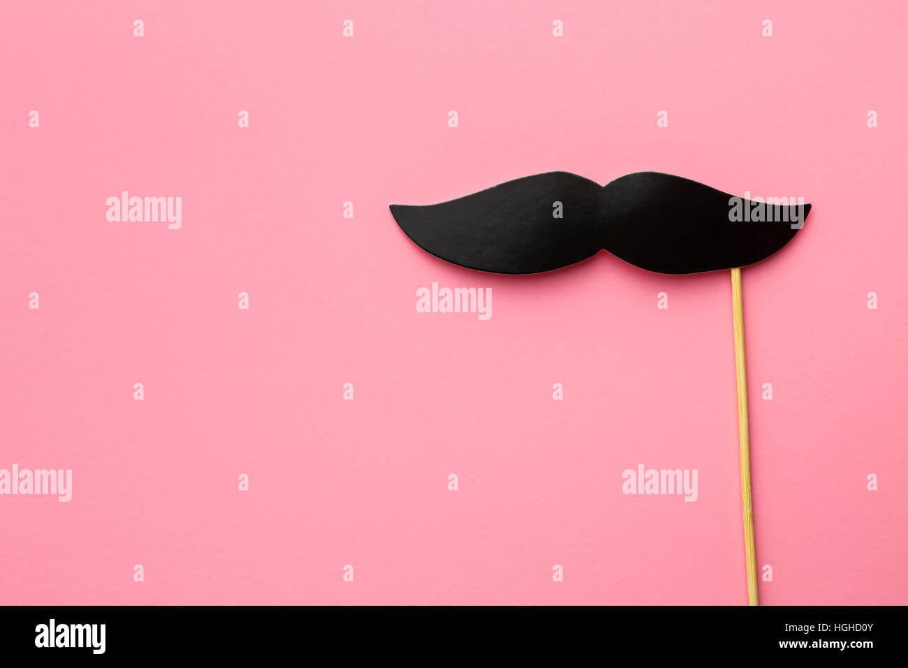 Fake black mustache on pink background. Stock Photo