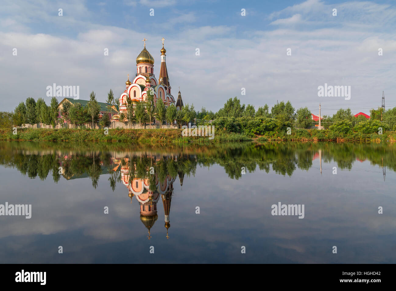 Russian orthodox church in Almaty, Kazakhstan known also as Church of Exaltation of the Holy cross, and its reflection in water. Stock Photo