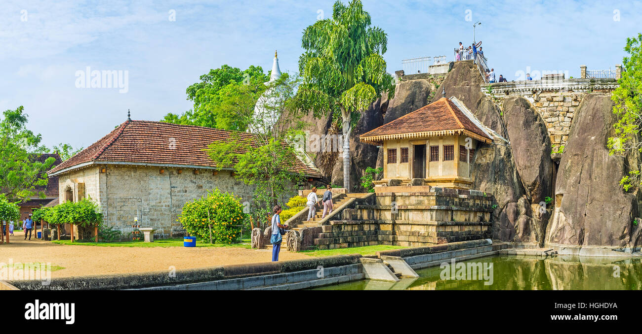 The complex of Isurumuniya Viharaya with the view on the Rock Temple, pond and the Stupa, hidden behind the trees Stock Photo