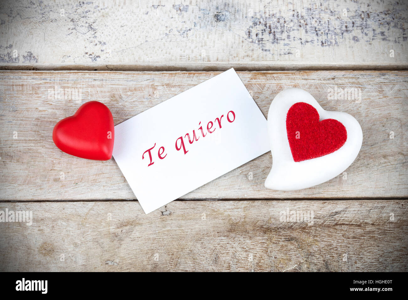 Valentine greeting card on wooden table with text written in spanish 'Te quiero', which means 'I love you'. Stock Photo