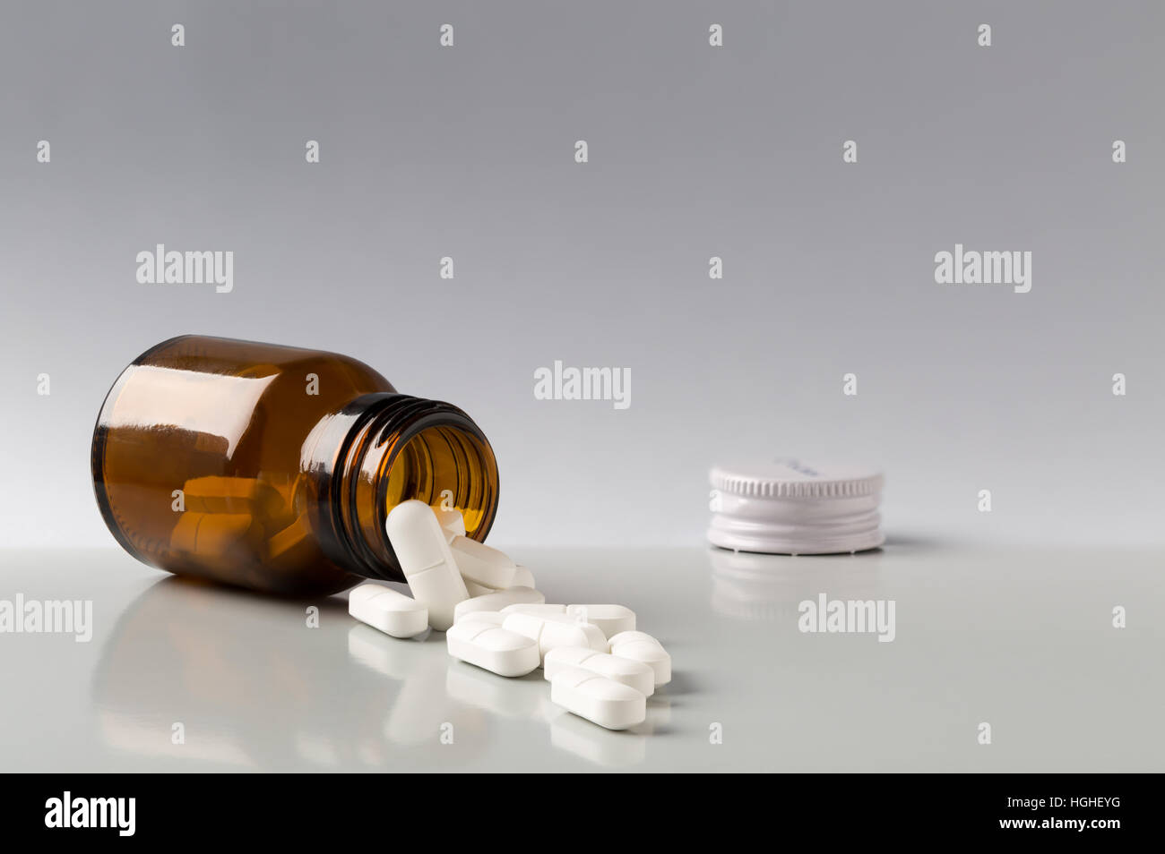 Brown glass pill bottle and white pills Stock Photo