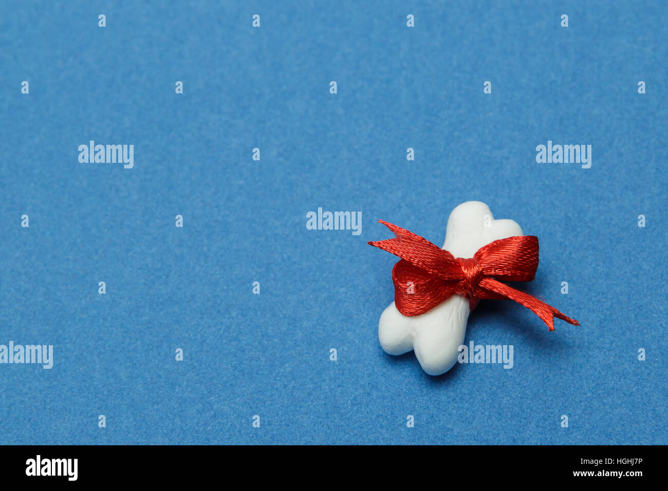 Toy a bone from plasticine on a blue background Stock Photo