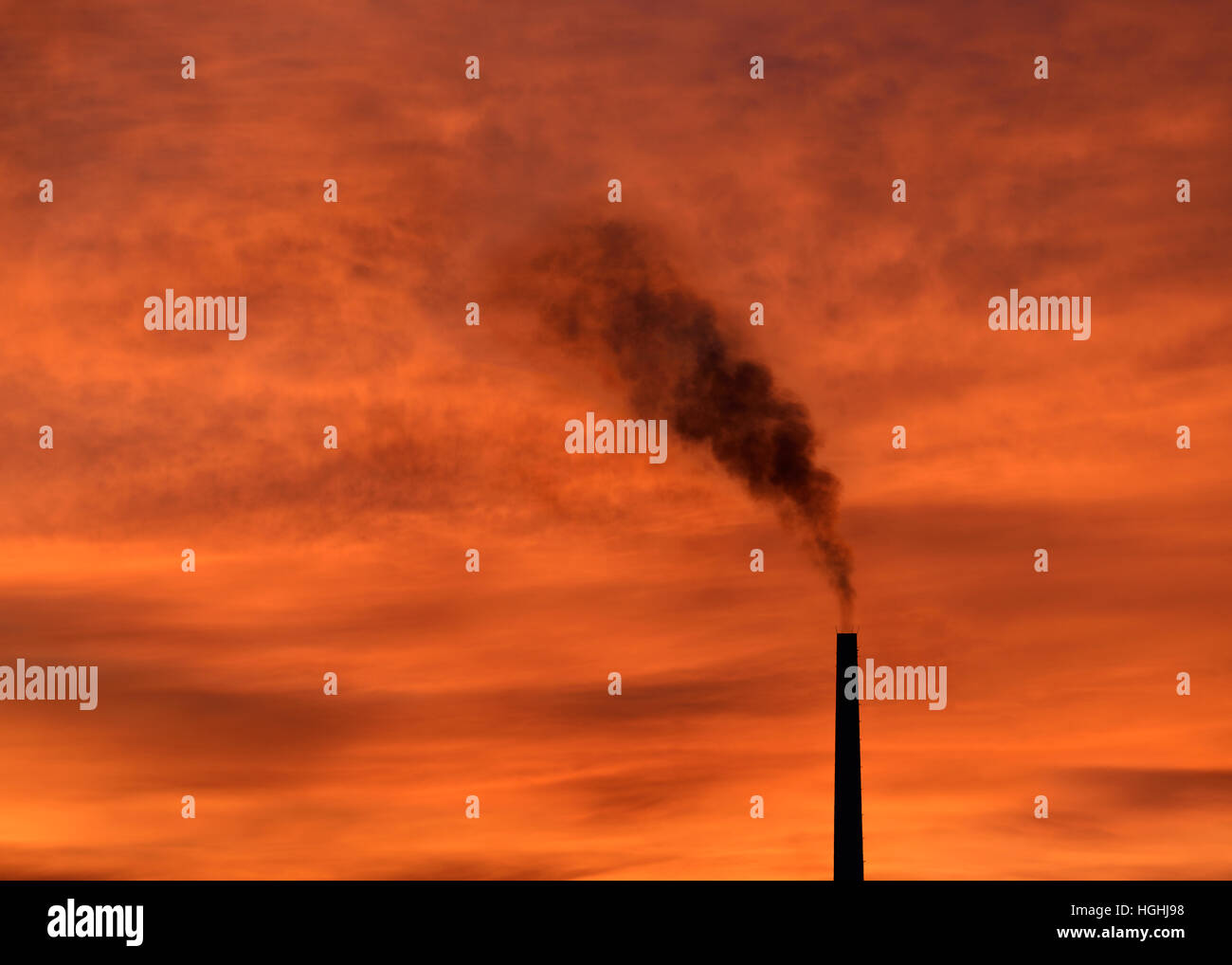 Smoke Emitting from a Factory Chimney at Sunset. Stock Photo