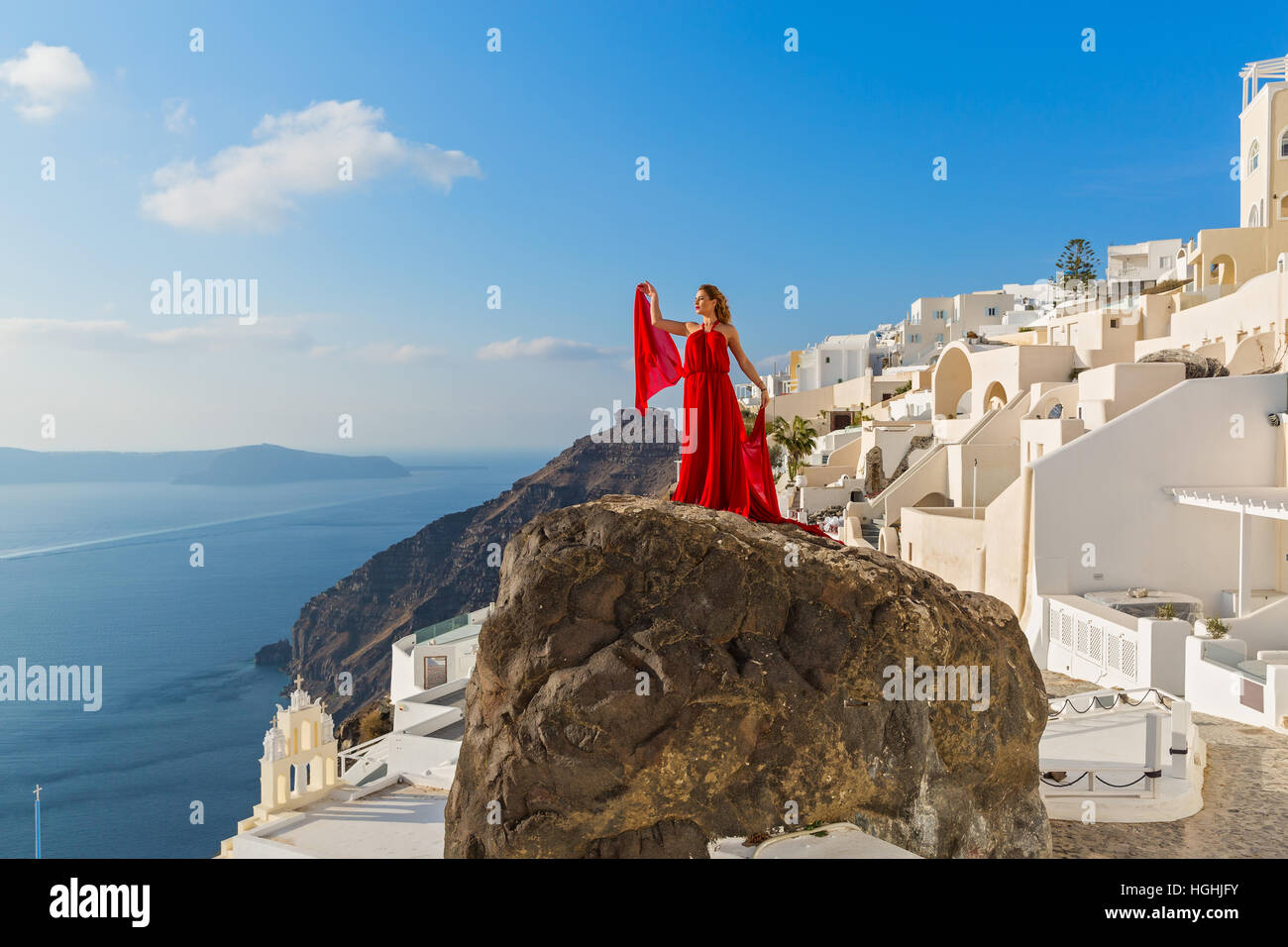 Beautiful woman in red dress stands on a high cliff Stock Photo - Alamy