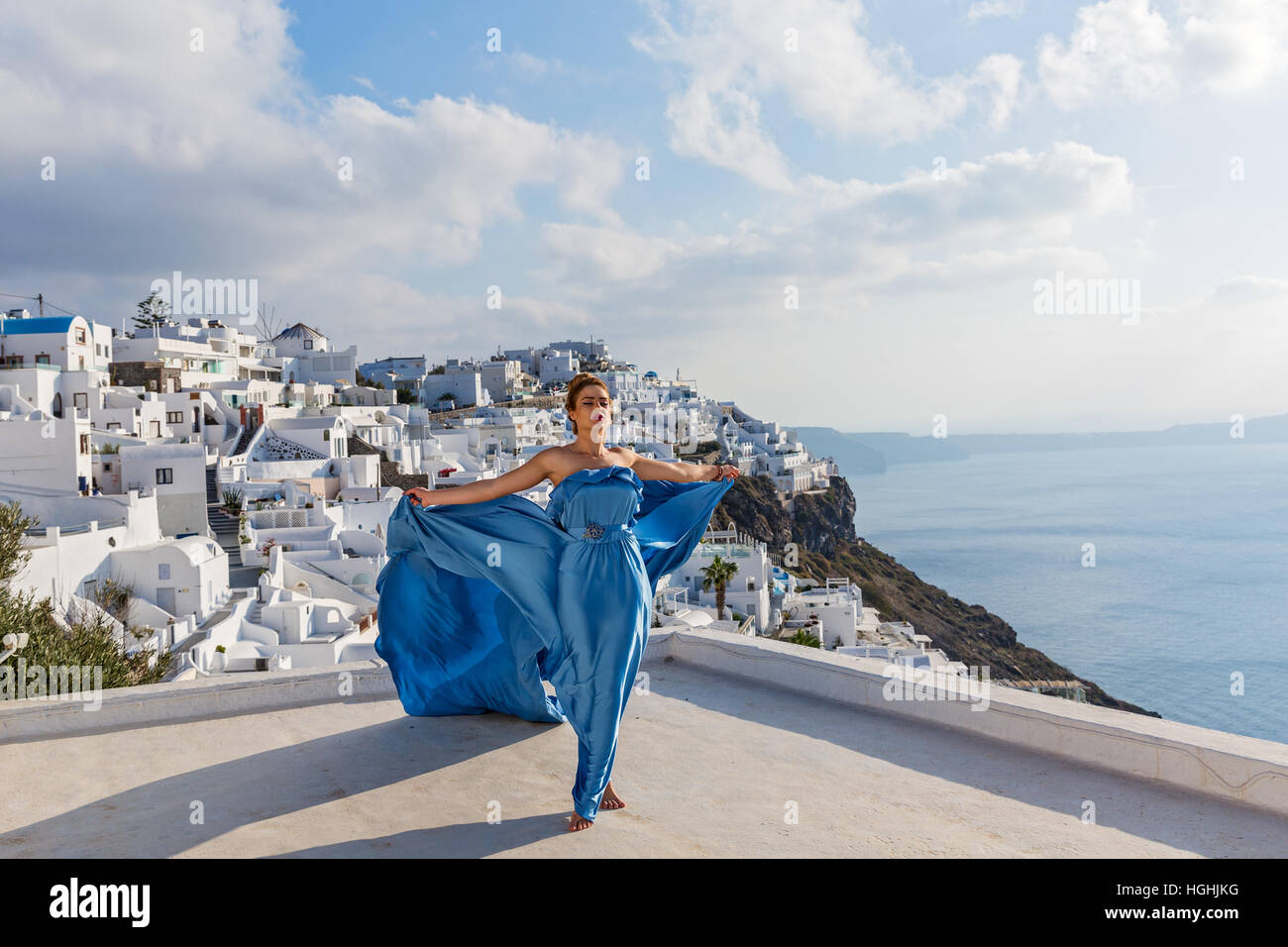 Woman in a beautiful blue dress with a long train on the island of ...