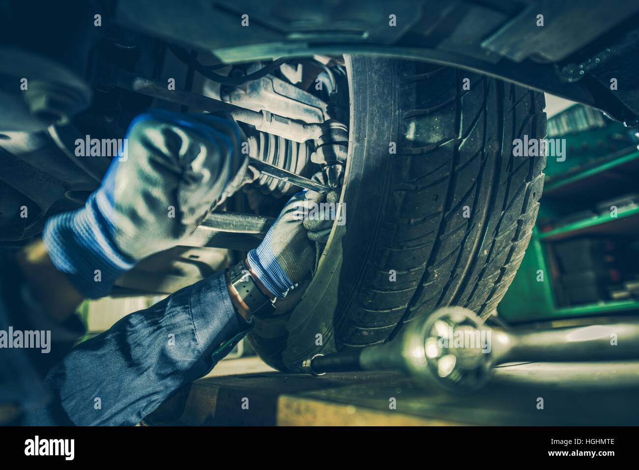Car Mechanic Fixing Tie Rod and Steering System While Being Under the