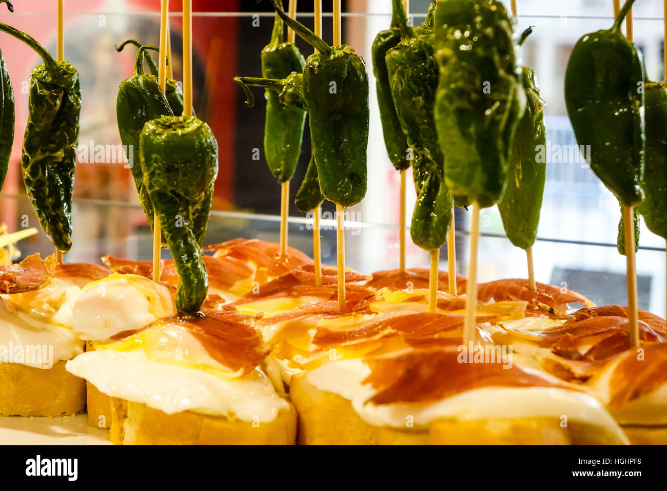 Tapas on display in glass cases on Spanish bar Stock Photo Alamy