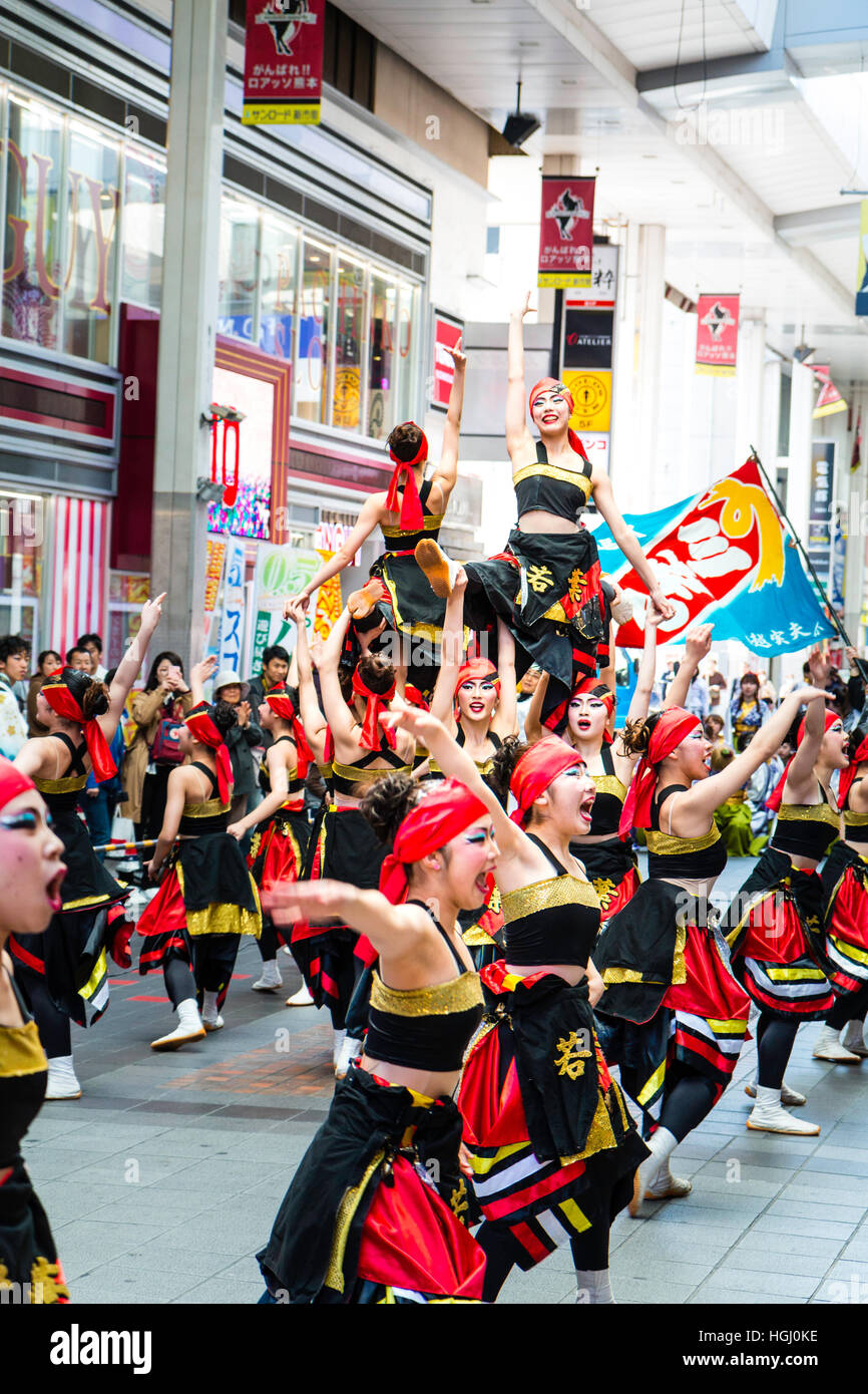 Japan, Kumamoto. Hinokuni Yosakoi Dance Festival. Female team performing historical dance in shopping arcade. Line of women, arms outstretched. Stock Photo