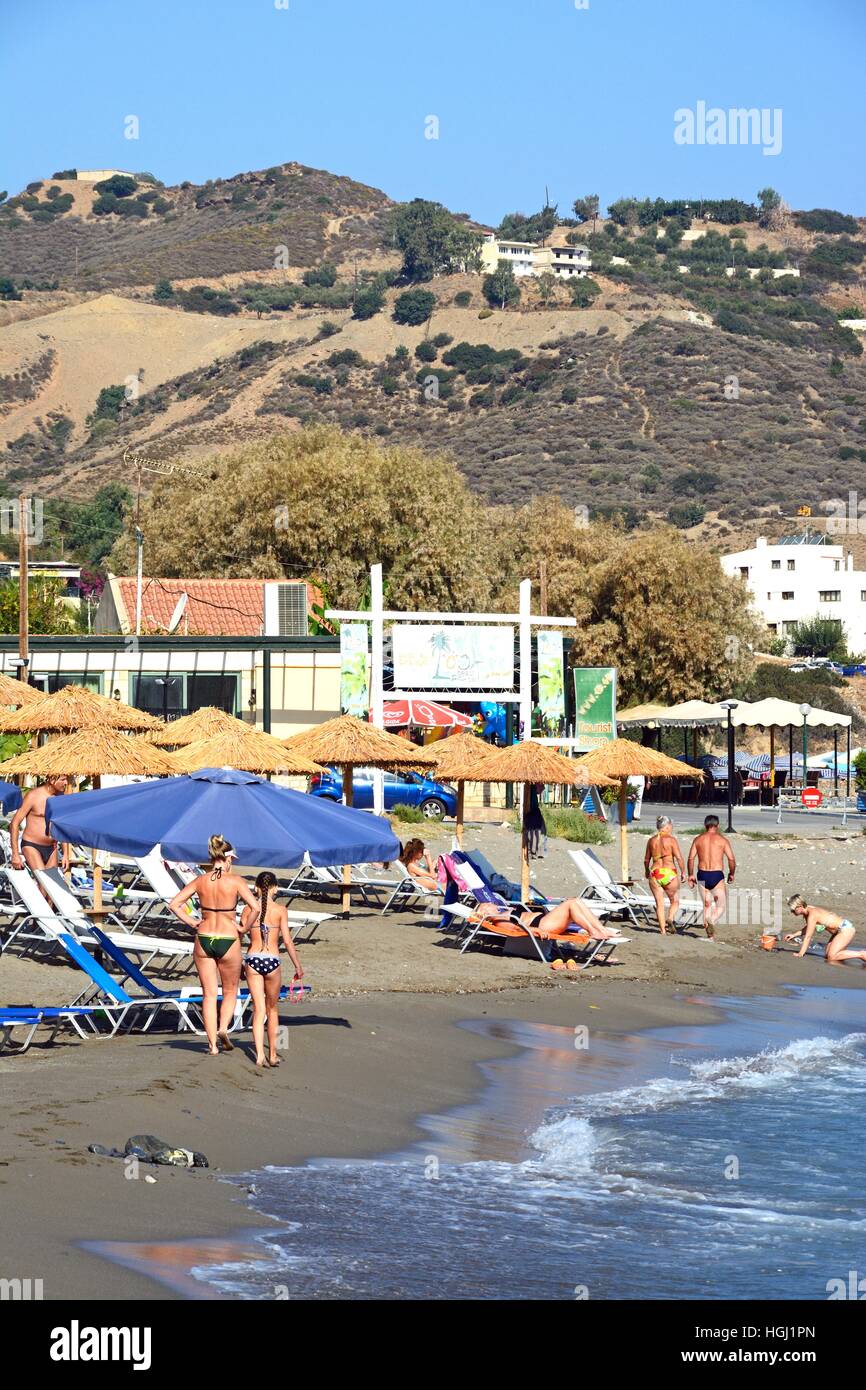 Tourists relaxing on Livadi Beach with restaurants to the rear, Bali, Crete, Greece, Europe. Stock Photo