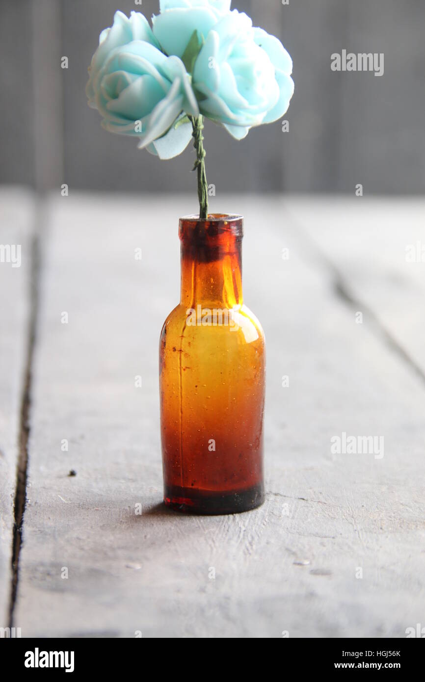 flowers in a bottle on wooden table Stock Photo