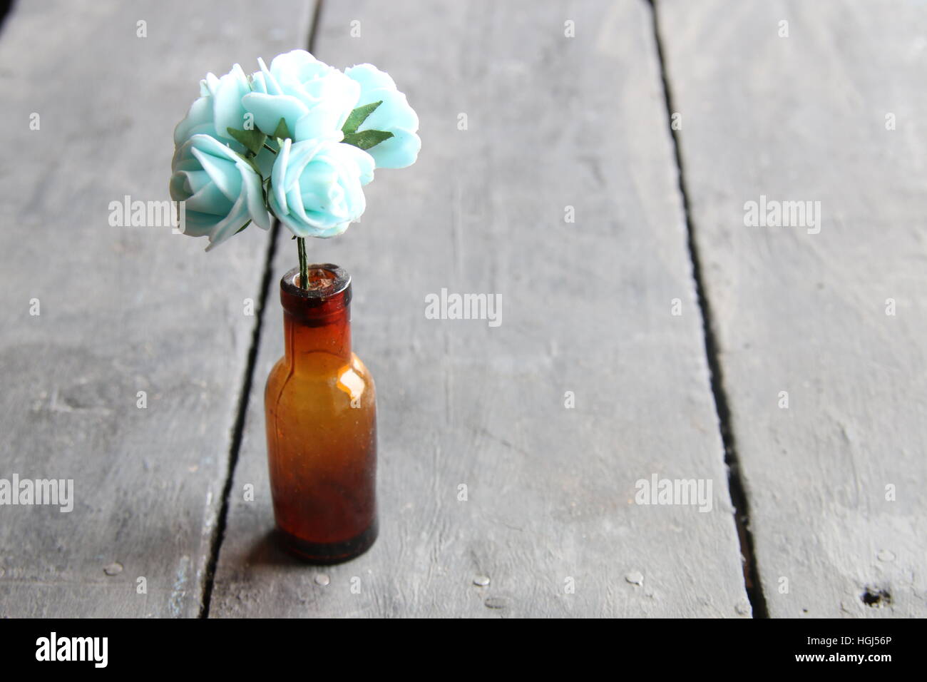 flowers in a bottle on wooden table Stock Photo