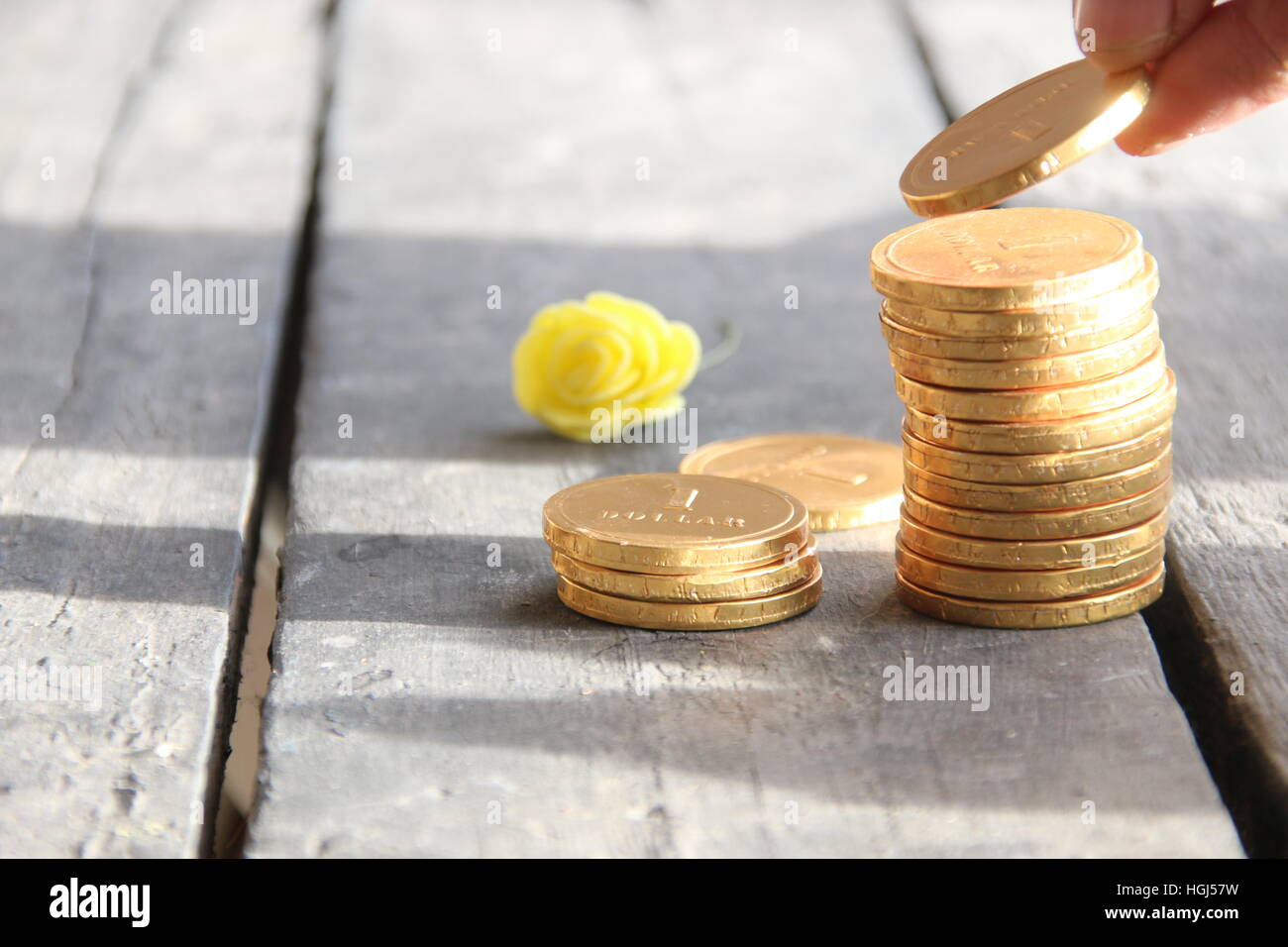 Stack coins with hand on wooden table Stock Photo
