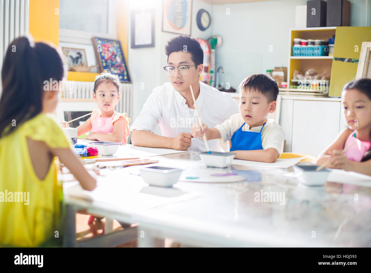 Little children painting in art class with teacher Stock Photo - Alamy