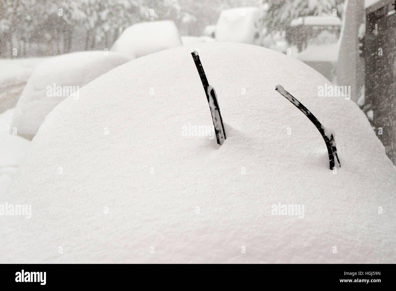 Car is fully covered with snow and lifted windshield wiper up against