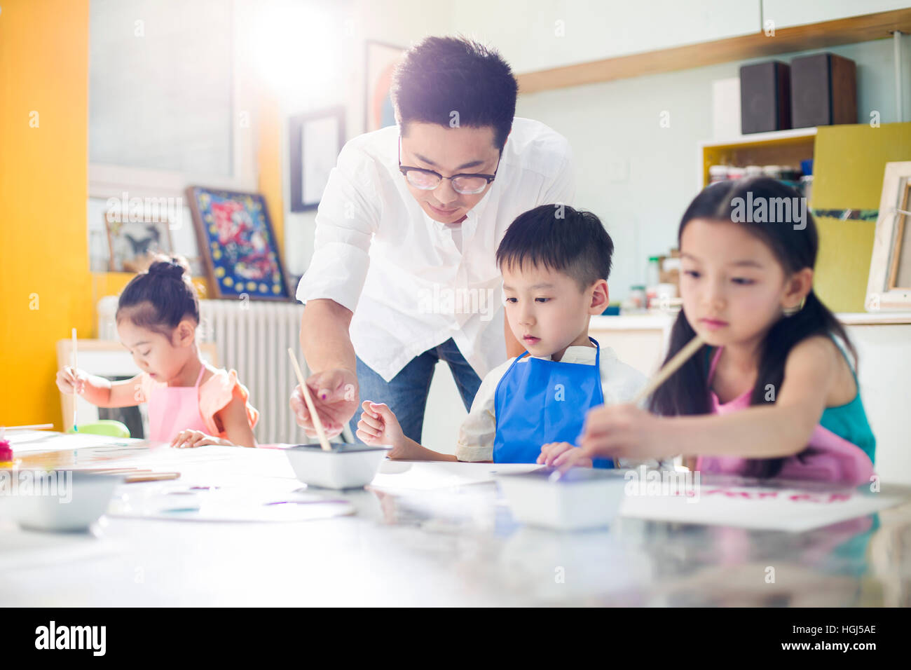 Little children painting in art class with teacher Stock Photo - Alamy