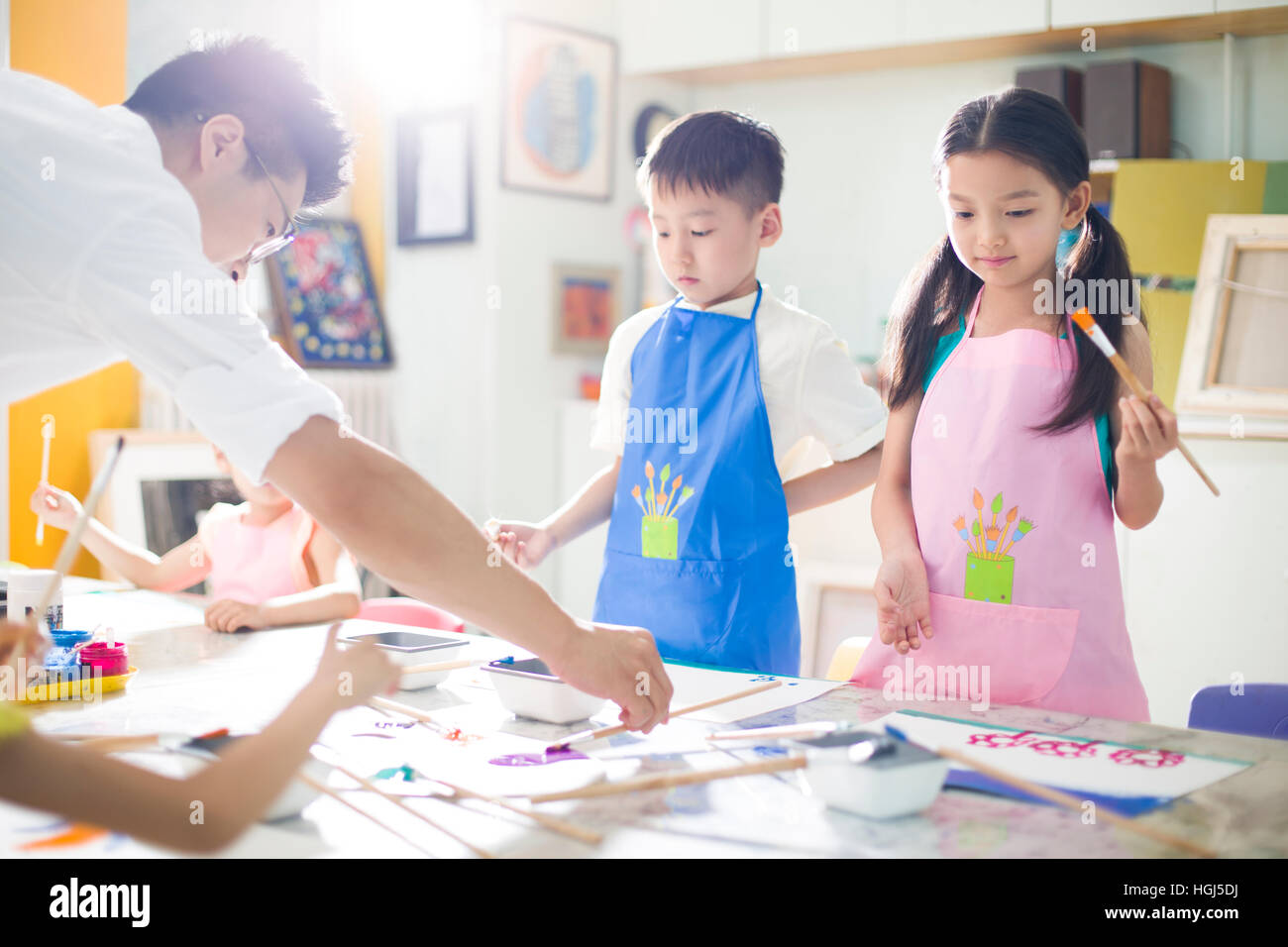 Little children painting in art class with teacher Stock Photo - Alamy