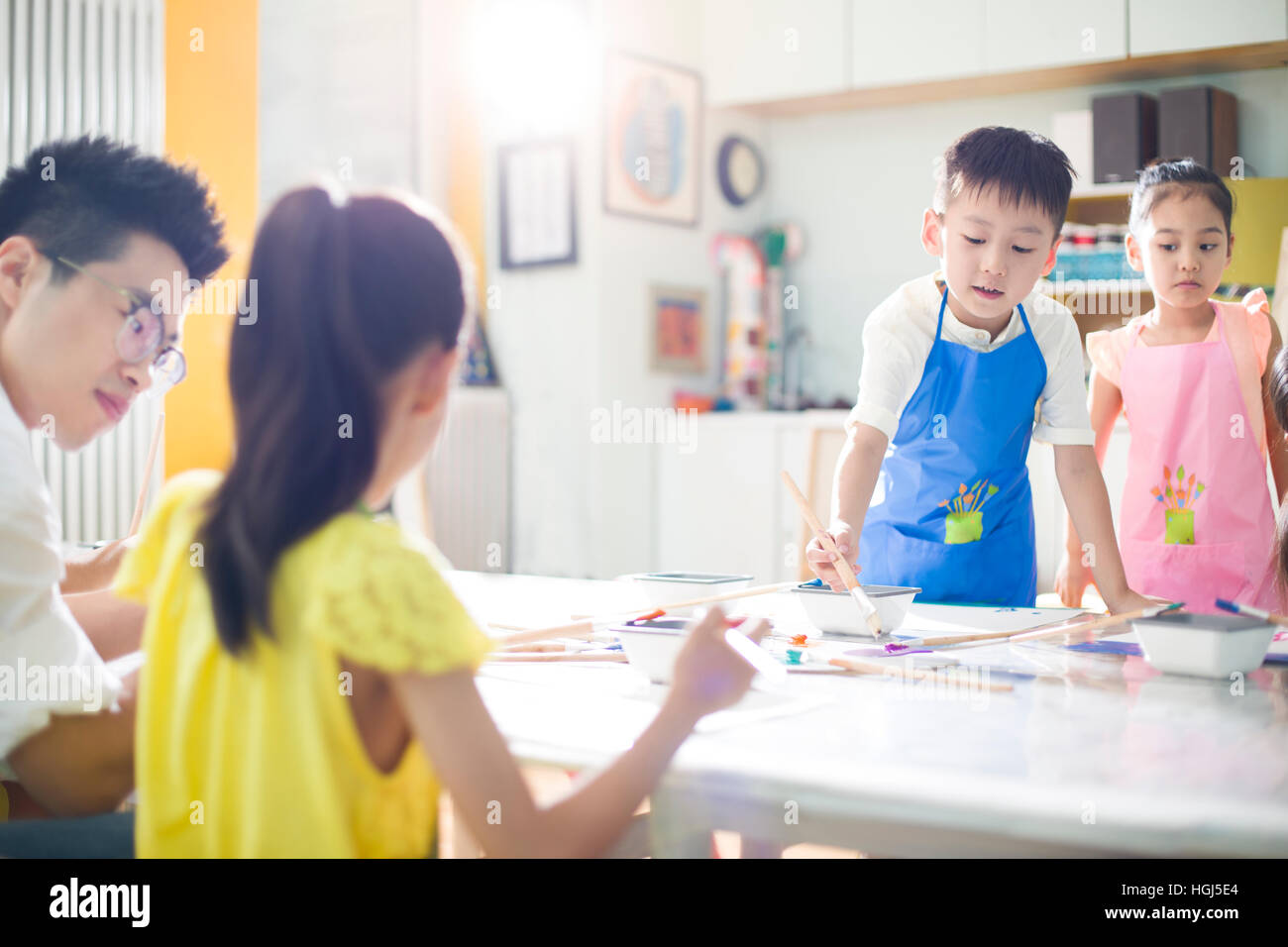 Little children painting in art class with teacher Stock Photo - Alamy