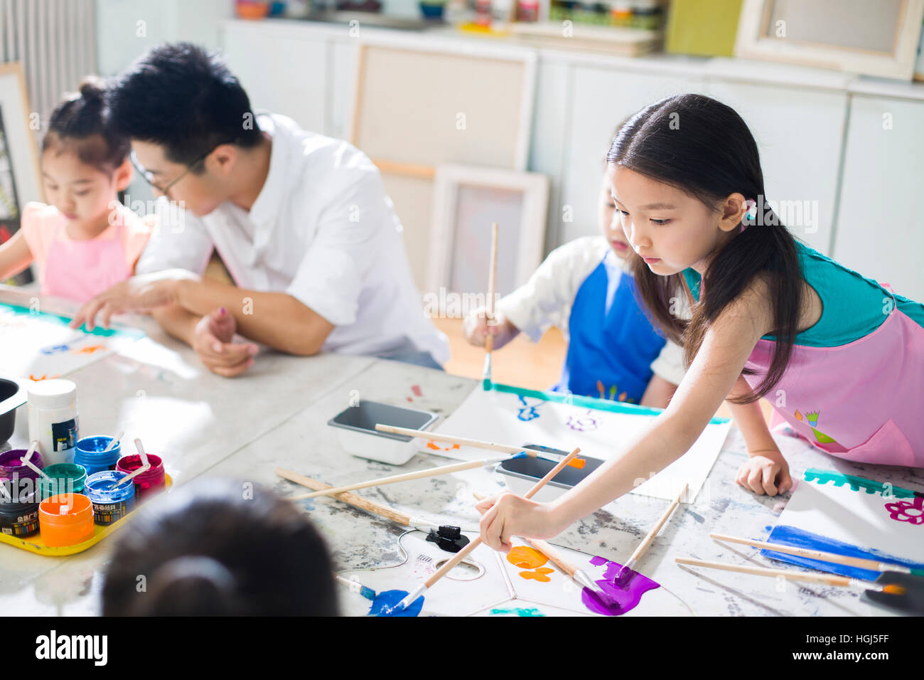 Little children painting in art class with teacher Stock Photo - Alamy
