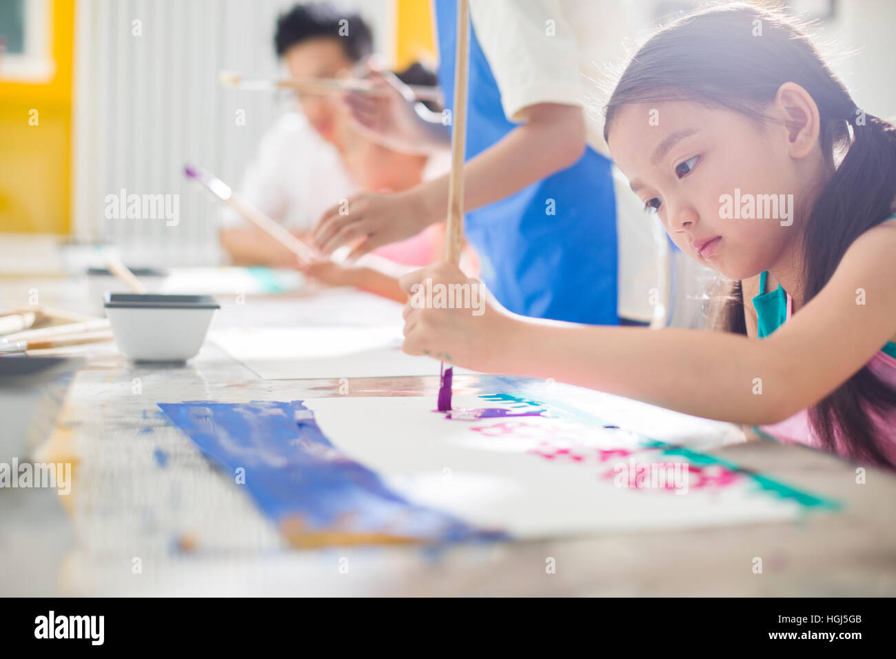 Little girl painting in art class Stock Photo - Alamy