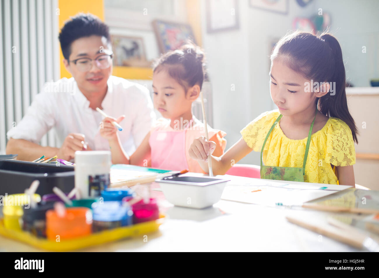 Little children painting in art class with teacher Stock Photo - Alamy