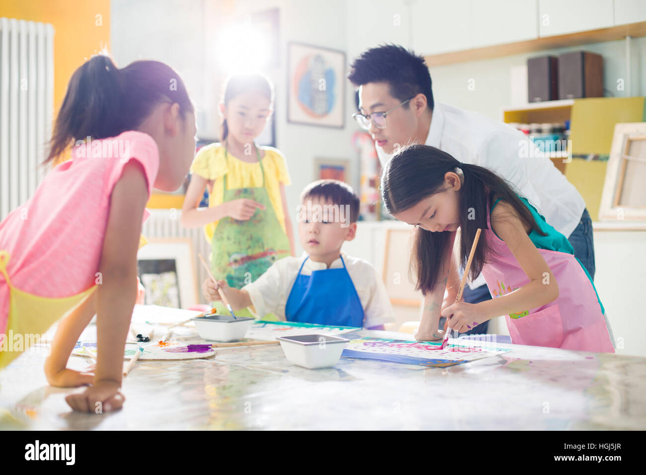 Little children painting in art class with teacher Stock Photo - Alamy