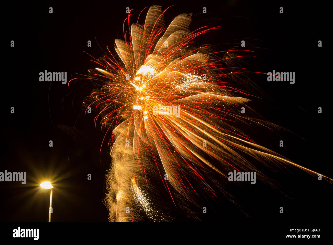 Red and yellow fireworks and a streetlight Stock Photo