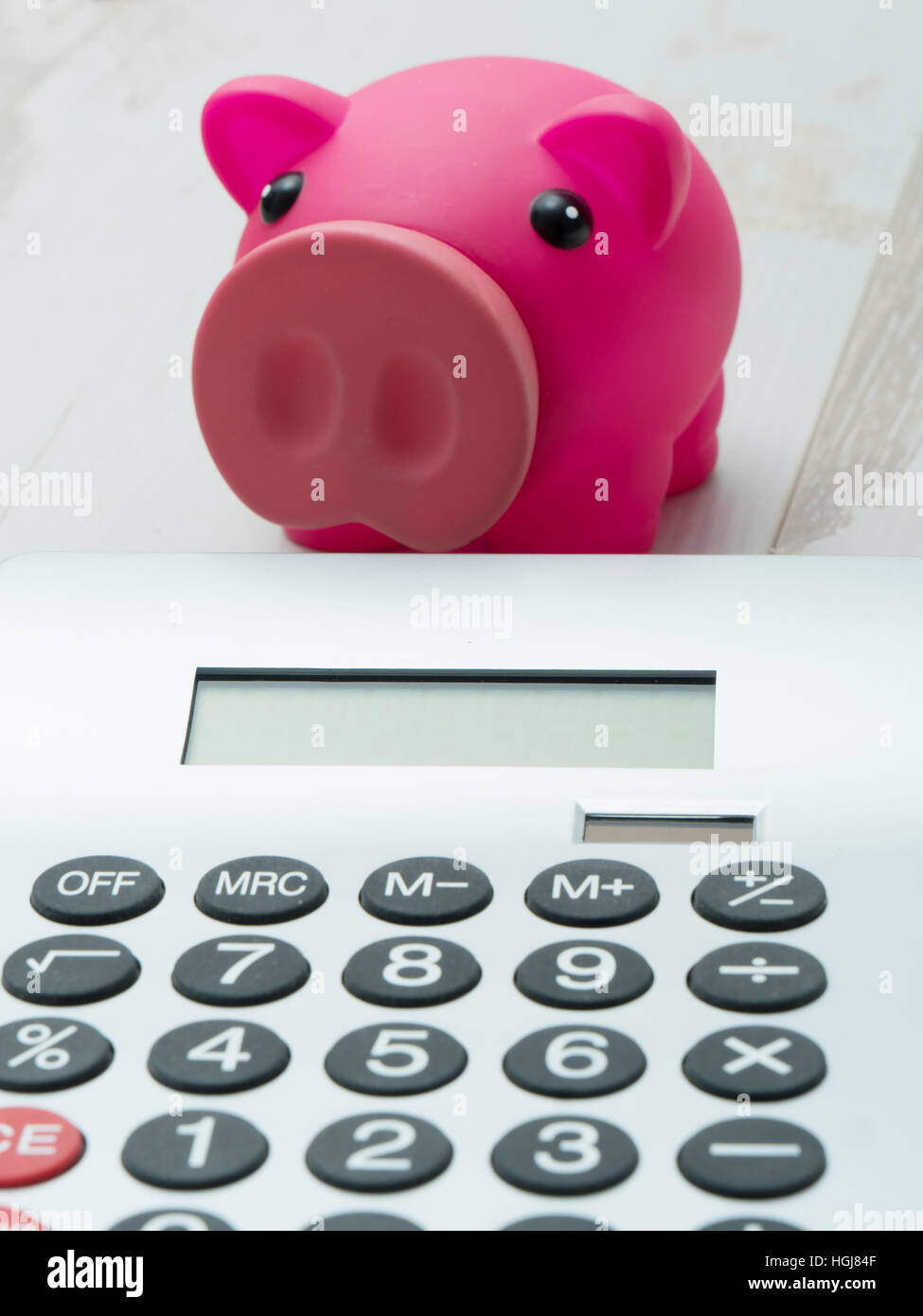a pink piggy bank and a calculator Stock Photo - Alamy