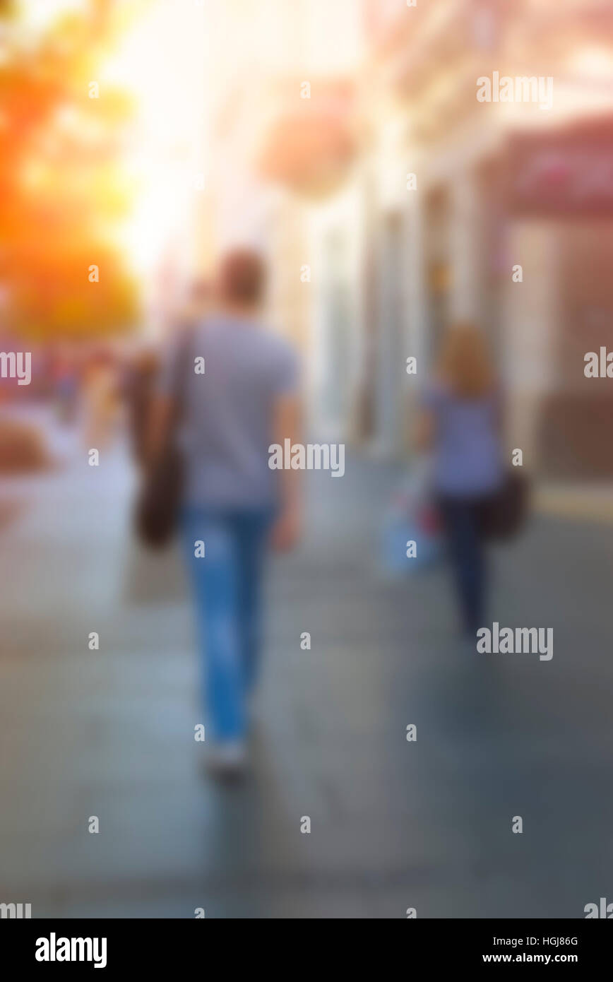 People walking down the street in the evening, high blurred image. Urban group of people in a city. Stock Photo
