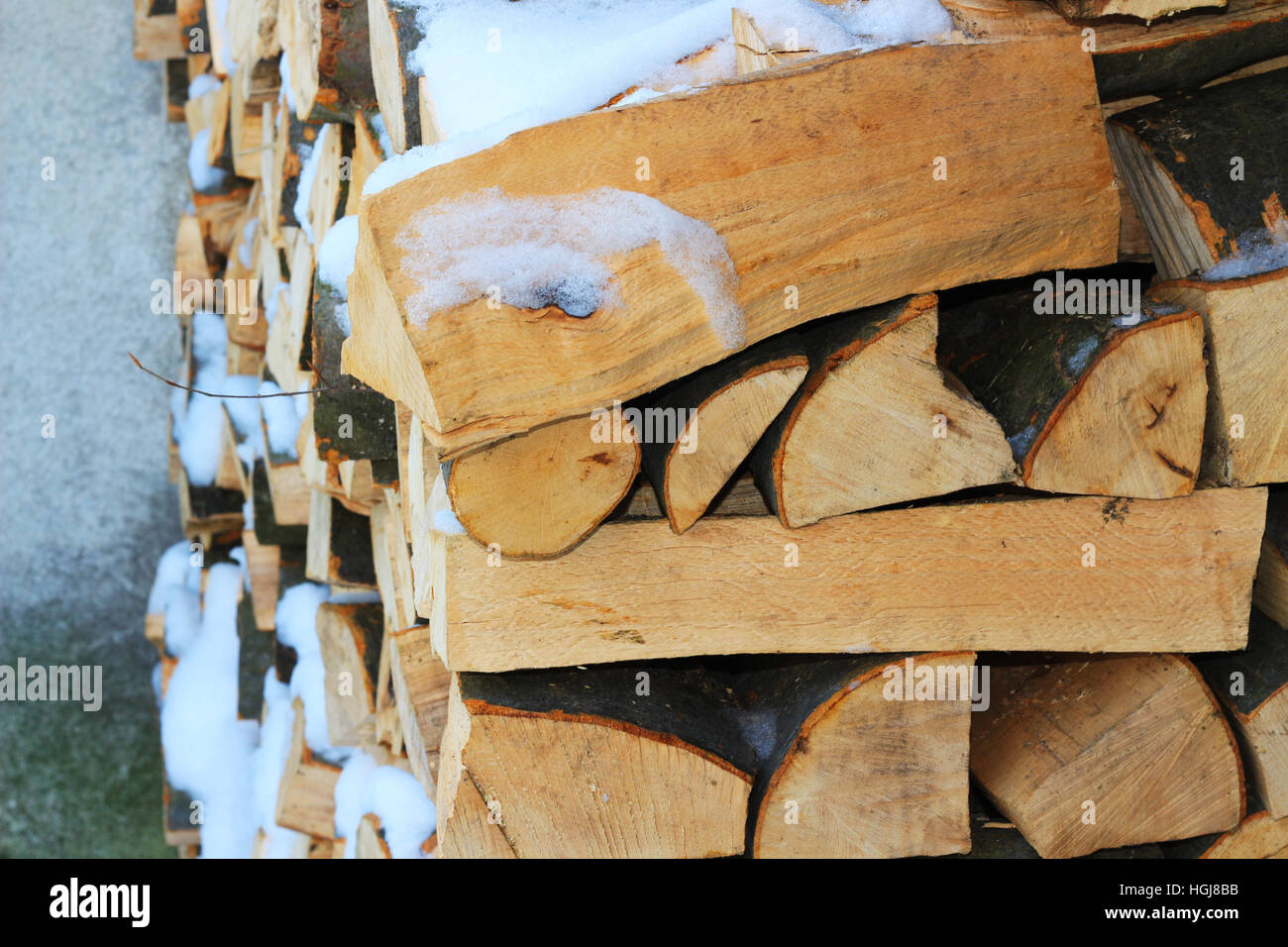 Stacked firewood in winter under the snow Stock Photo Alamy