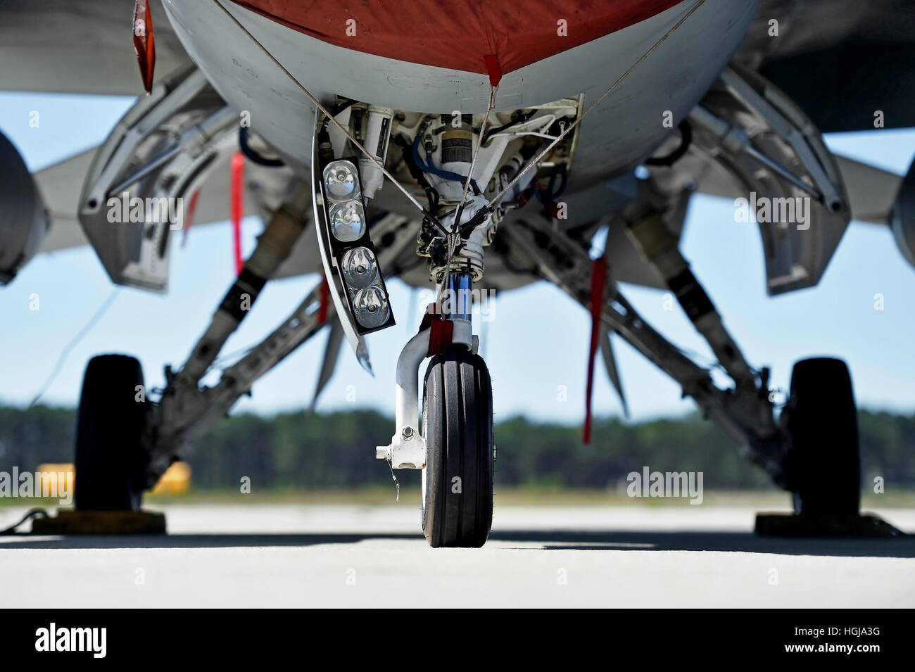 Military aircraft detail with landing gear and engine cover on a runway Stock Photo