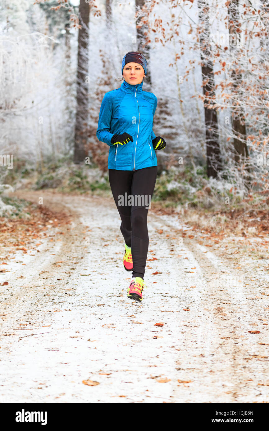 a young woman jogging in the wintry forest Stock Photo - Alamy