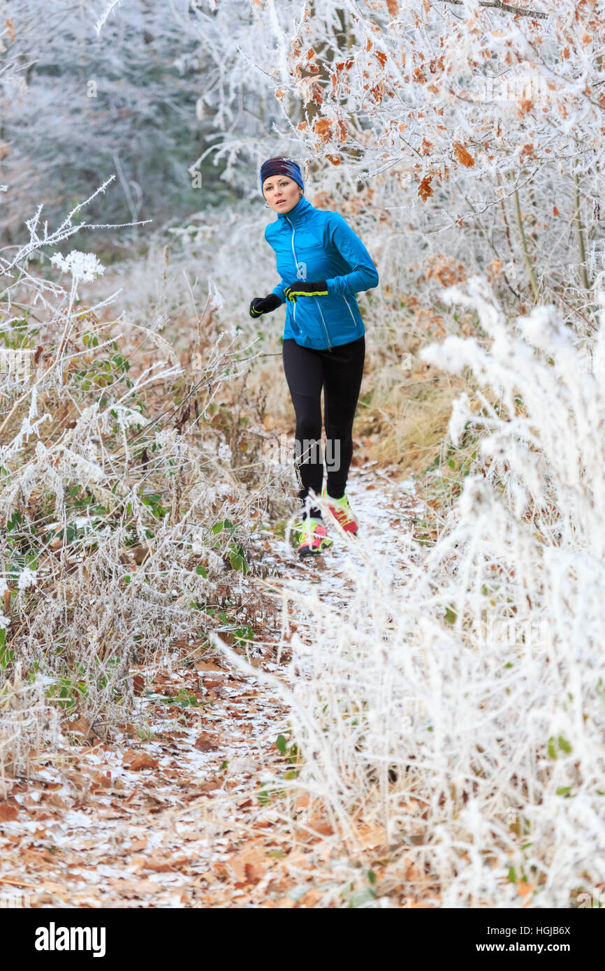 a young woman jogging in the wintry forest Stock Photo - Alamy