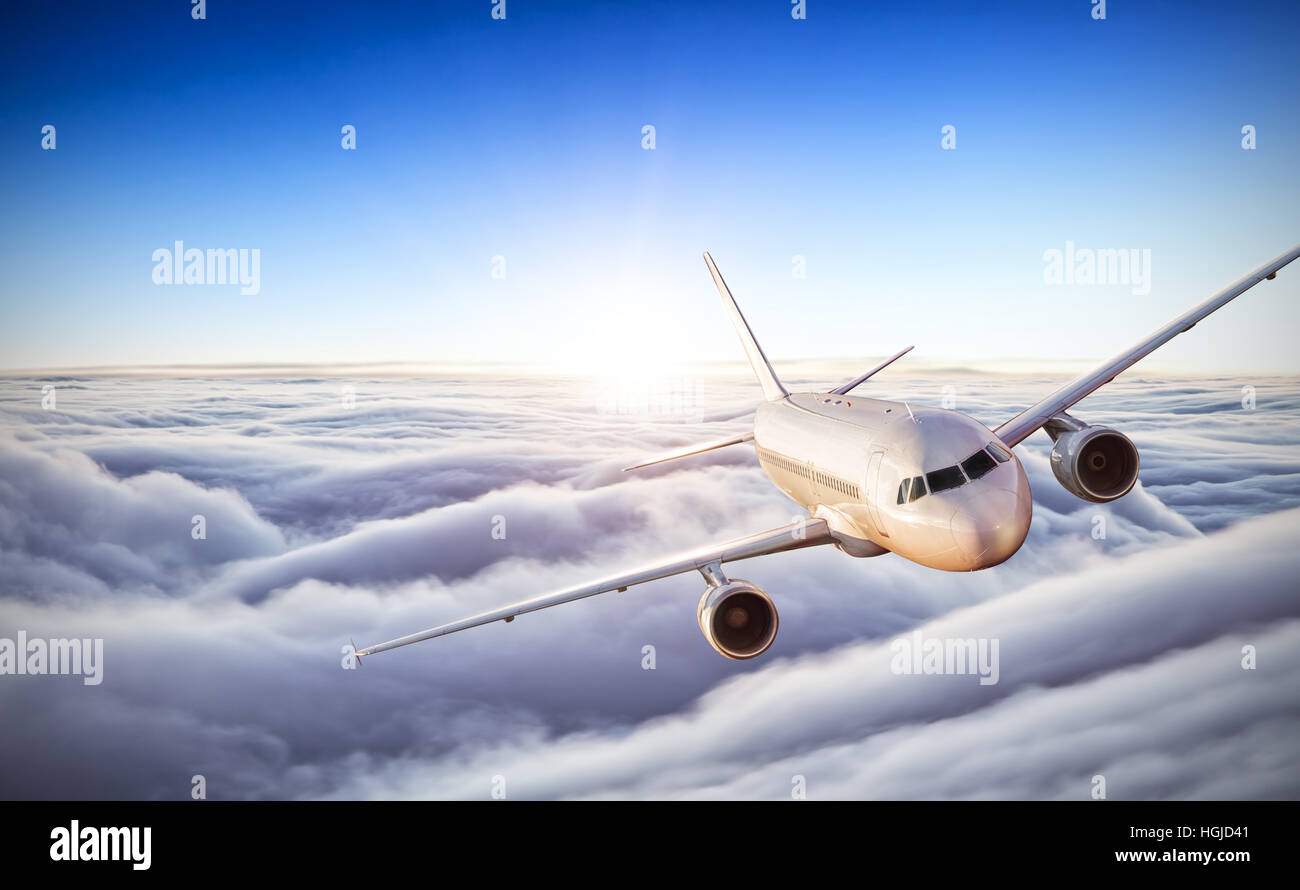 Commercial airplane flying above clouds in dramatic sunset light. Very ...