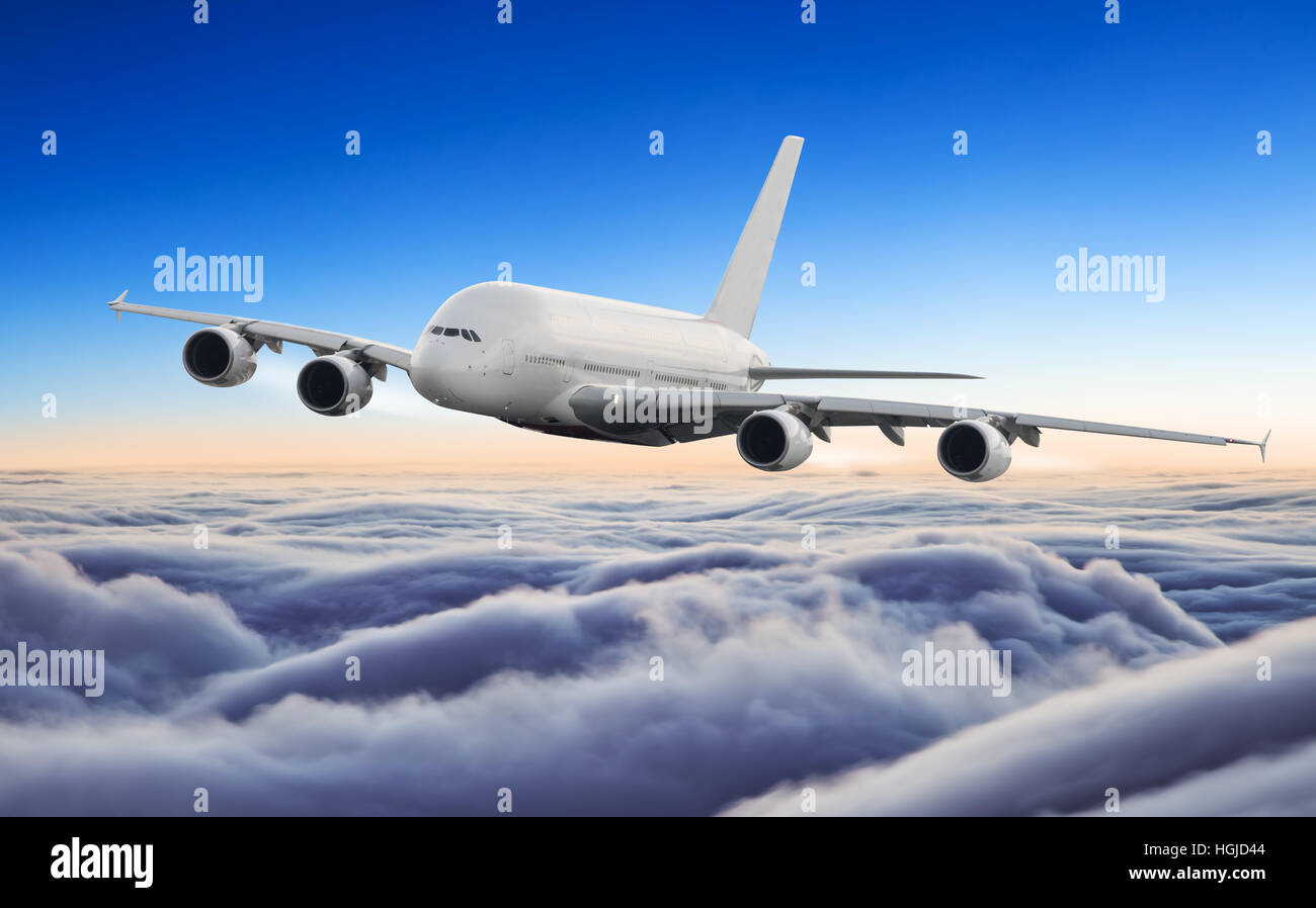 Huge commercial airplane flying above clouds in dramatic sunset light ...