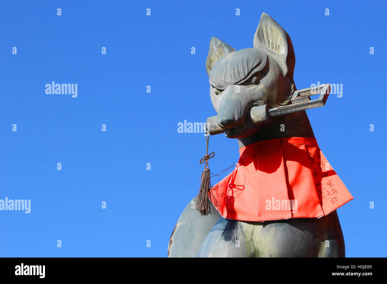 Fox statue at the entrance of Fushimi Inari Shrine in Kyoto, holding a key in its mouth Stock Photo