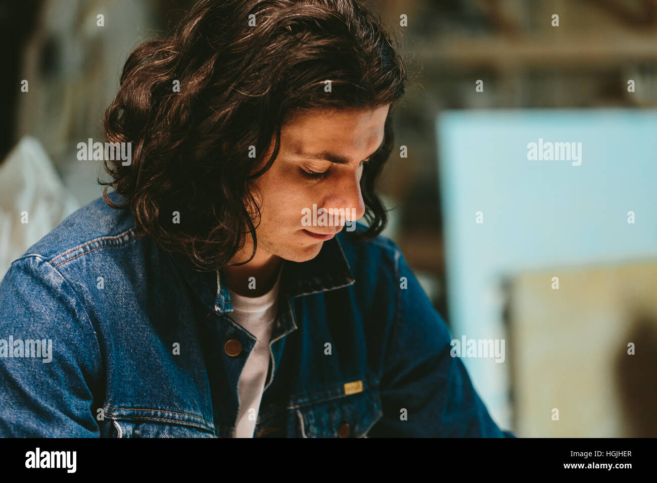 handsome man with long hair brunette in a denim jacket Stock Photo