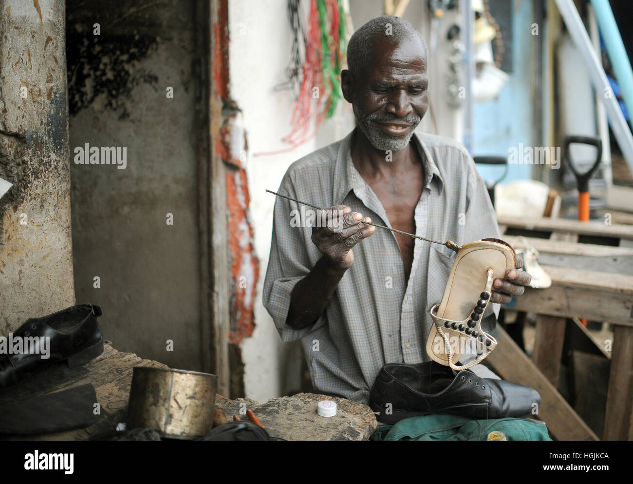 Lusaka, Zambia. 09th Mar, 2016. A cobbler repairs shoes in the alleyways of the Chawama area of Lusaka, Zambia, 09 March 2016. Photo: Britta Pedersen/dpa-Zentralbild/ZB/dpa/Alamy Live News Stock Photo