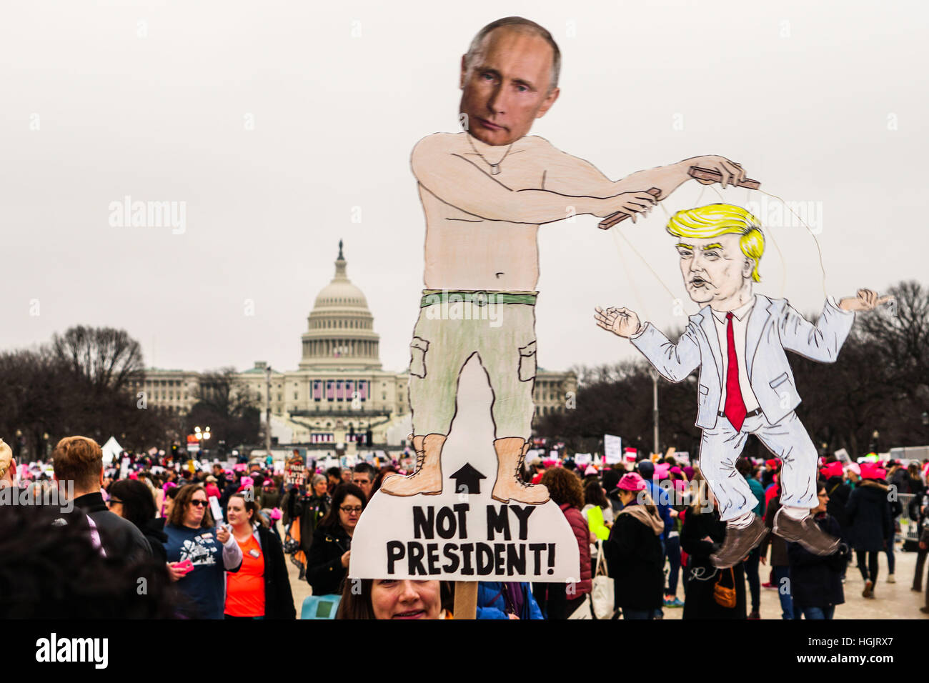 Washington, DC, USA. 21st Jan, 2017. A protestor holds an anti-Putin and anti-Trump signs during the Women's March on Washington in Washington, DC.  with the U.S. Capitol in the background. Large crowds attended the anti-Trump rally the day after the U.S. Stock Photo