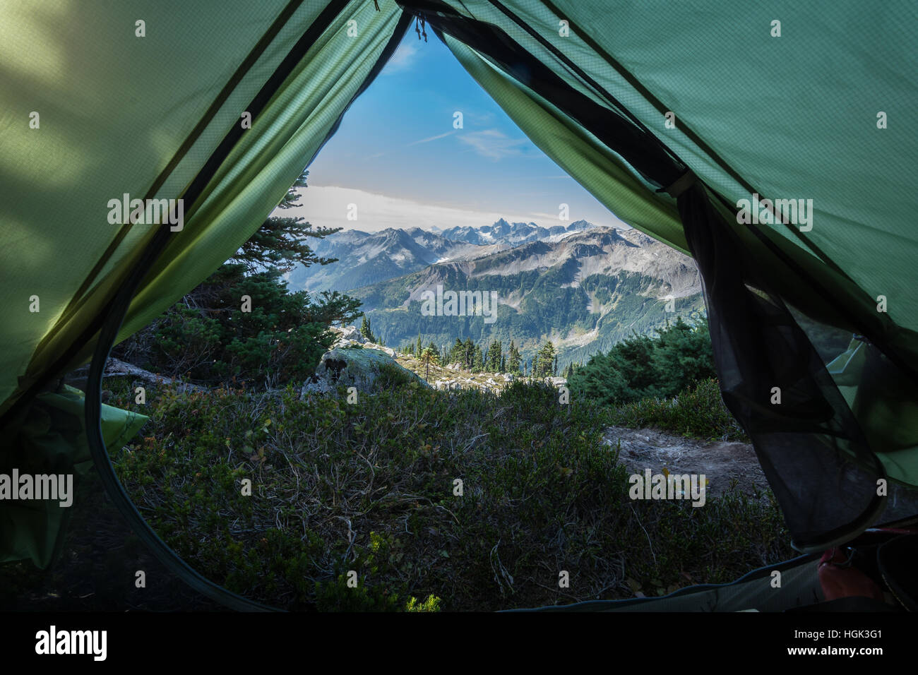Looking out of a tent door to the mountains. Stock Photo