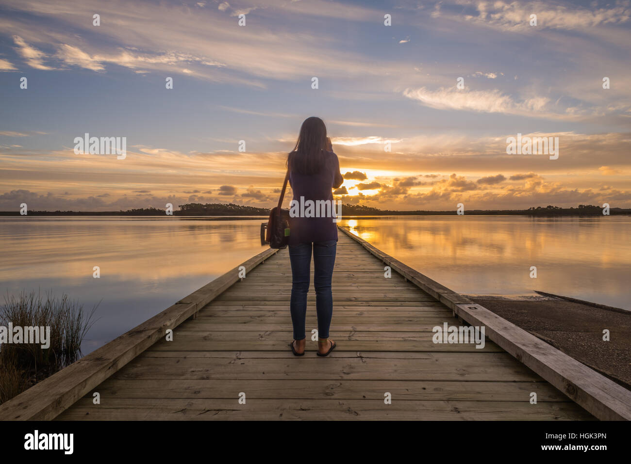 Girl photographing the Sunset Stock Photo - Alamy