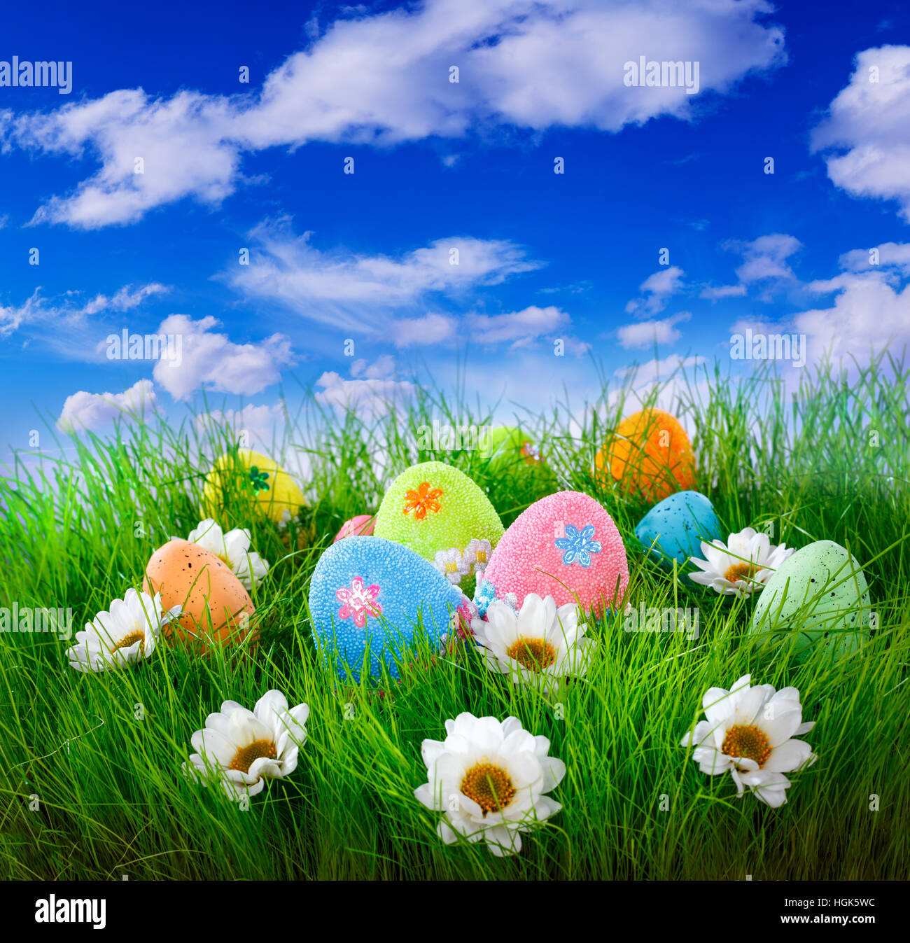 Decorated easter eggs in the grass on blue sky background Stock Photo ...