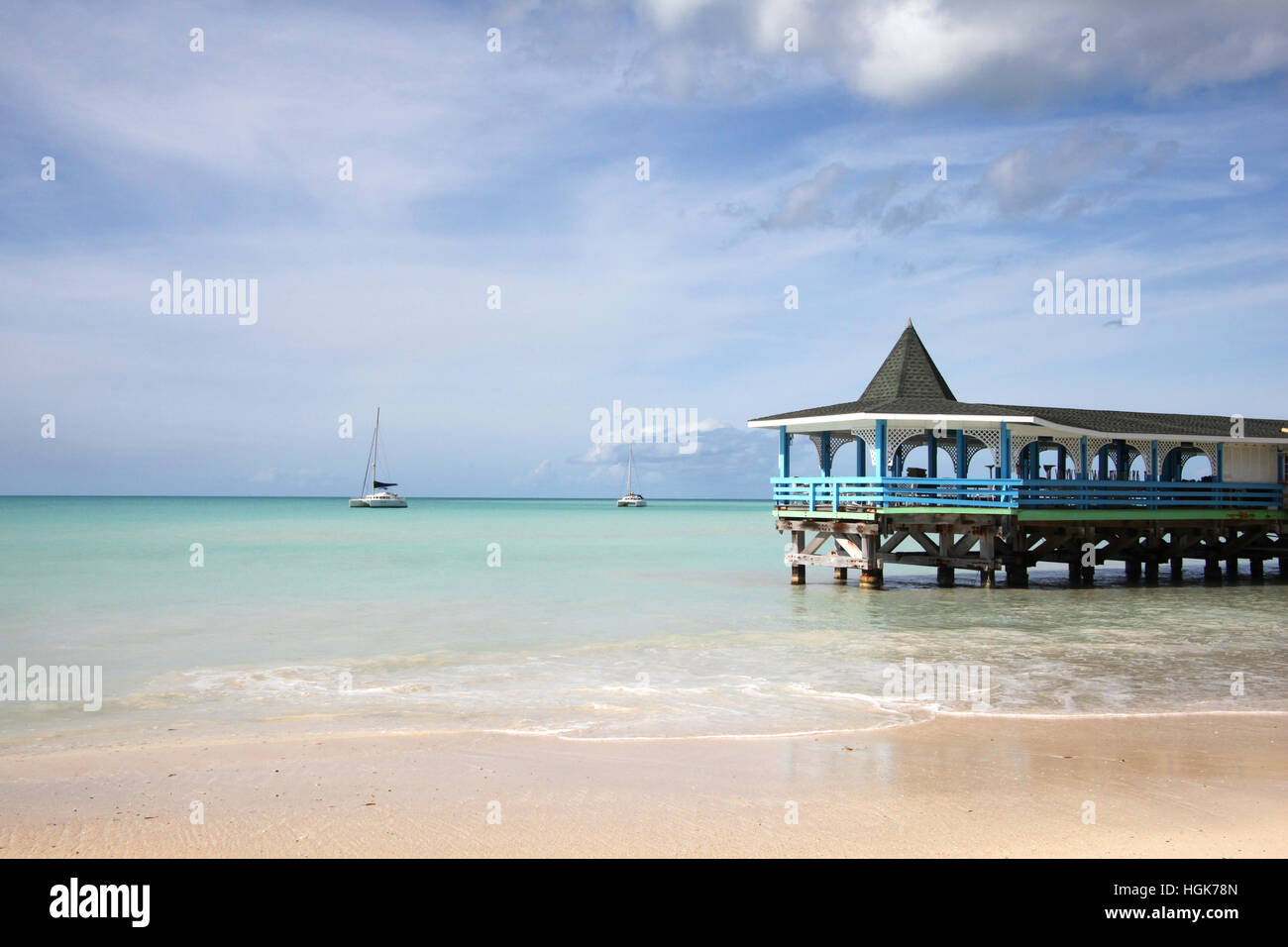 Beautiful day with a view out to sea & the pier of Runaway Beach, Antigua, Caribbean. Stock Photo