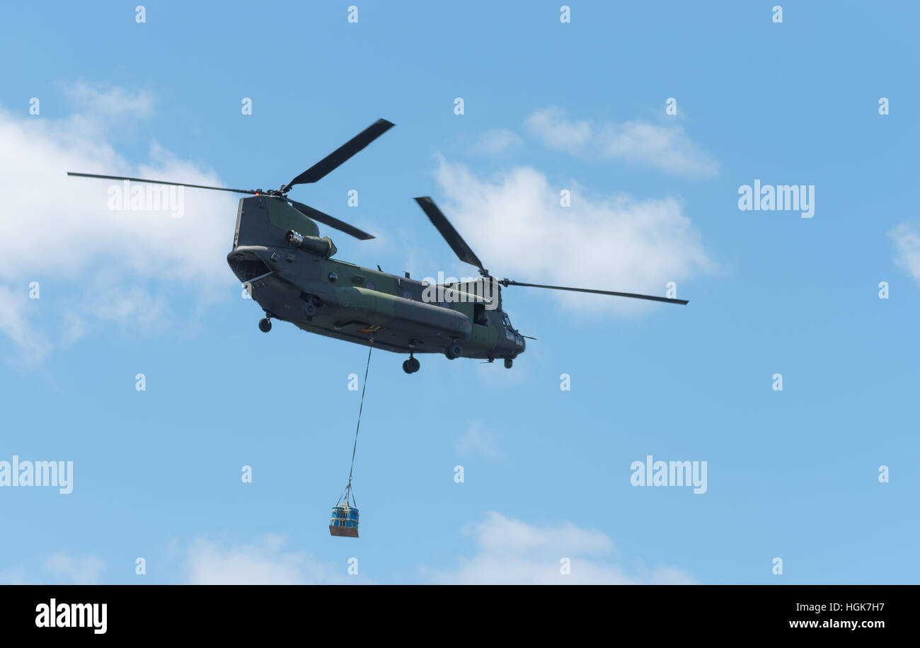 Double rotor, heavy airlift, military helicopter, in flight, carrying cargo.  Heavy airlift military helicopter in flight. Stock Photo