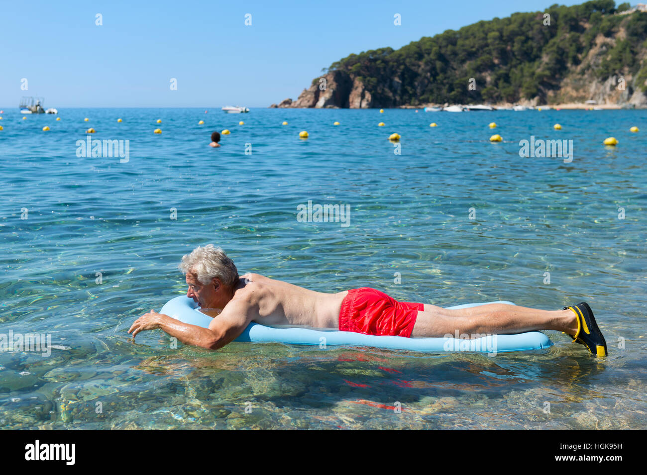 Tanned and fit senior man wearing blue swim trunks and a pair of goggles  standing on a diving board over a swimming pool Stock Photo - Alamy